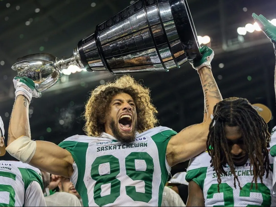 Kian Schaffer-Baker of the Saskatchewan Roughriders hoists the Grey Cup